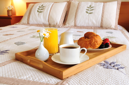 Tray with breakfast on a bed in a hotel room